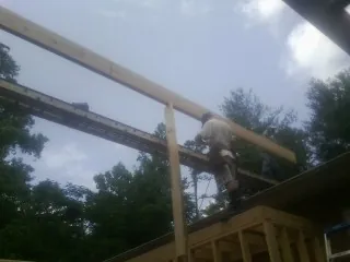 Carpenter setting a ridge beam over a new addition frame — Ice Dam Removal by Roofing Brothers in Harrodsburg