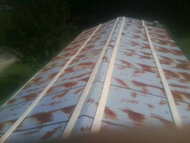 Rusted metal roof panels with new wood purlins before replacement — Storm Damage Roof Repair in Harrodsburg by Roofing Brothers